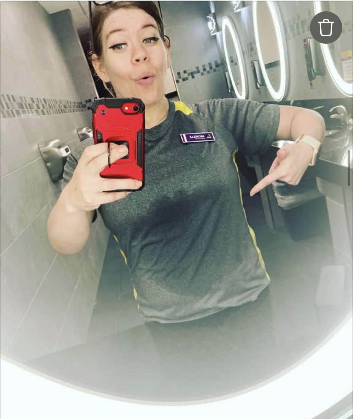 Michelle in her fitness staff uniform taking a gym mirror photo.