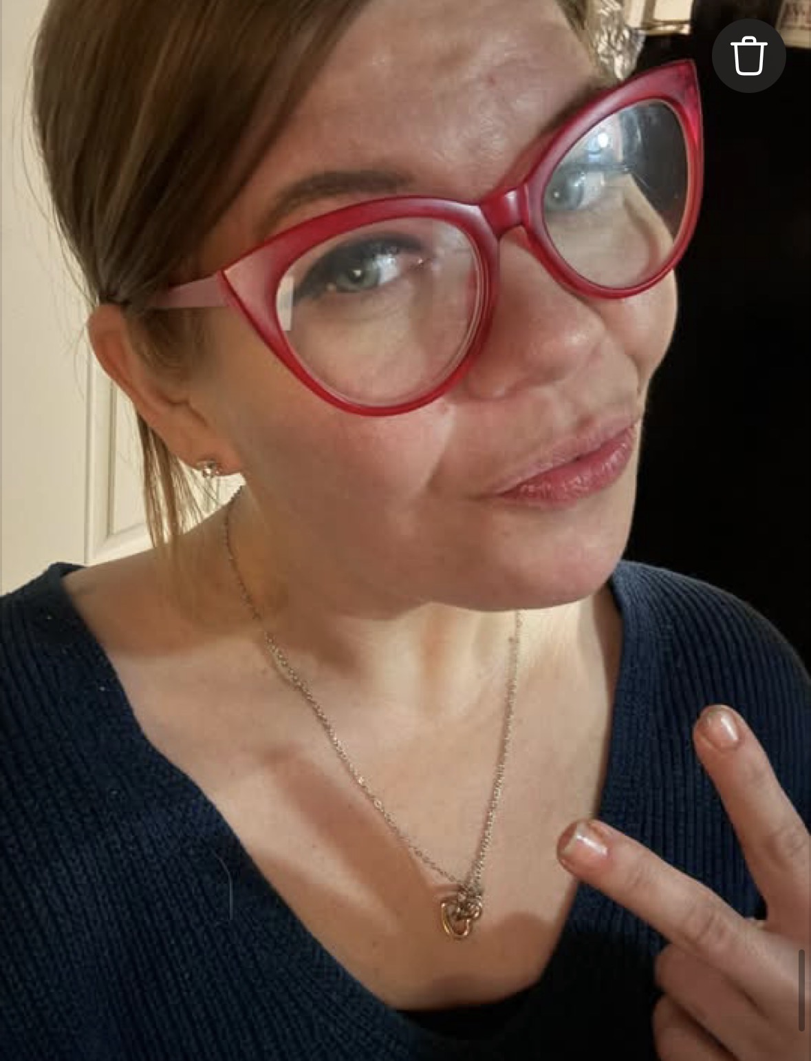 A portrait of Michelle wearing red glasses.
